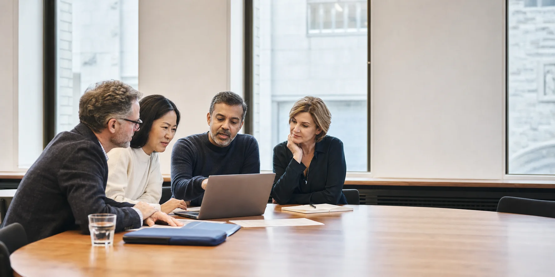 A cross-functional university team working together around a laptop